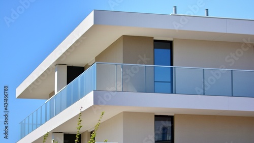 Condominium and apartment building with symmetrical modern architecture. Detail in modern residential flat apartment building exterior. Fragment of new luxury house and home complex. 