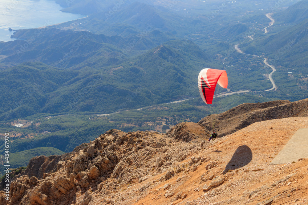 Paragliders flying from a top of Tahtali mountain near Kemer, Antalya Province in Turkey. Concept of active lifestyle and extreme sport adventure Paragliders flying from a top of Tahtali mountain near Kemer, Antalya Province in Turkey. Concept of active lifestyle and extreme sport adventure