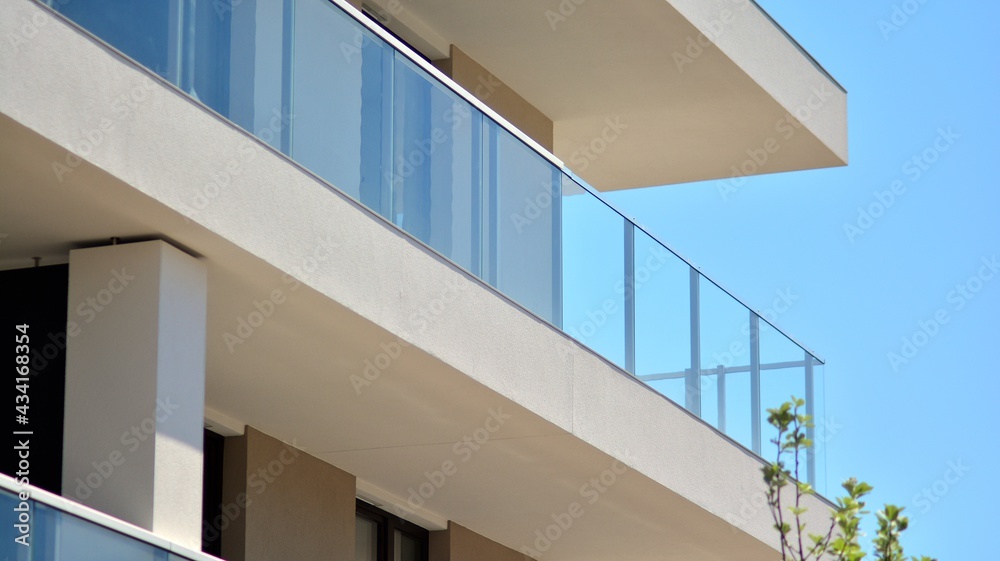 Condominium and apartment building with symmetrical modern architecture. Detail in modern residential flat apartment building exterior. Fragment of new luxury house and home complex. Condominium and apartment building with symmetrical modern architecture. Detail in modern residential flat apartment building exterior. Fragment of new luxury house and home complex.