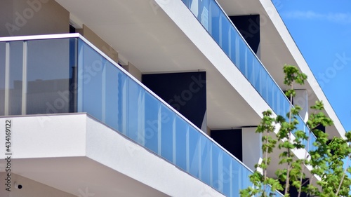 Condominium and apartment building with symmetrical modern architecture. Detail in modern residential flat apartment building exterior. Fragment of new luxury house and home complex. 