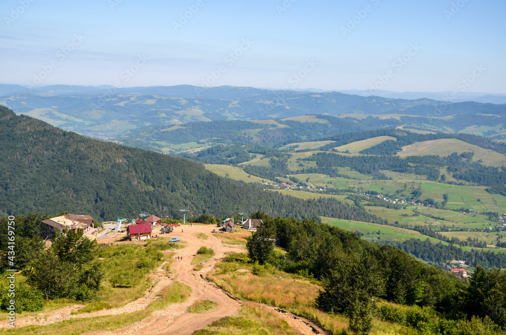 Scenic view to upper cable car station in village Pylypets from Gymba Mountain. Beautiful panorama of Carpathian Mountains on background. Ukraine