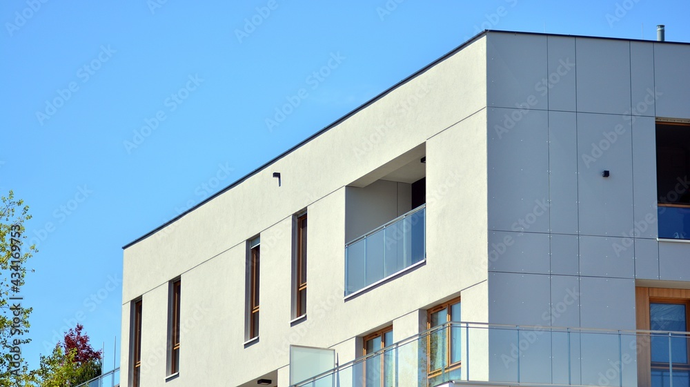 Condominium and apartment building with symmetrical modern architecture. Detail in modern residential flat apartment building exterior. Fragment of new luxury house and home complex. Condominium and apartment building with symmetrical modern architecture. Detail in modern residential flat apartment building exterior. Fragment of new luxury house and home complex.