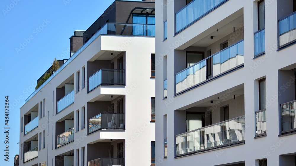 Condominium and apartment building with  symmetrical modern architecture. Detail in modern residential flat apartment building exterior. Fragment of new luxury house and home complex.