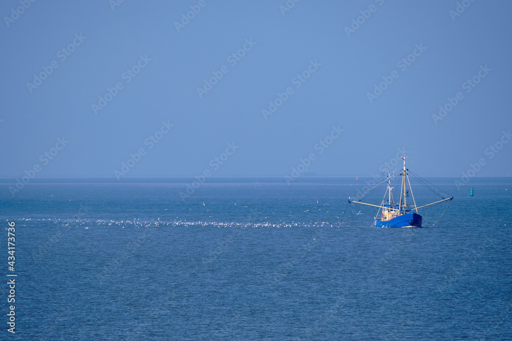 Obraz premium Ameland, Netherlands-April,19,2021: Fishing boat, nets and seagulls on the Wadden Sea. Fisherman conflict escalates: British, French and Dutch arguing over North Sea and electric pulse fishing