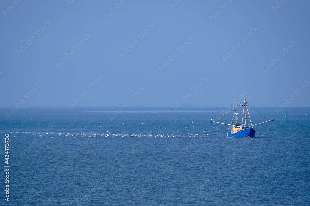 Ameland, Netherlands-April,19,2021: Fishing boat, nets and seagulls on the Wadden Sea. Fisherman conflict escalates: British, French and Dutch arguing over North Sea and electric pulse fishing