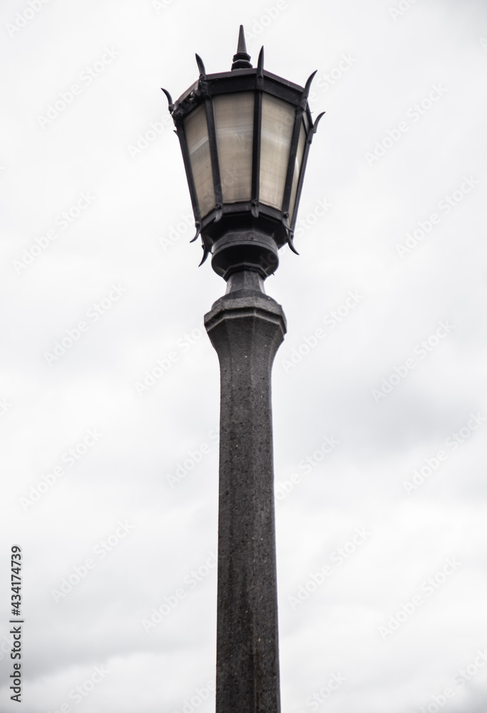 Lamppost top against overcast sky. 