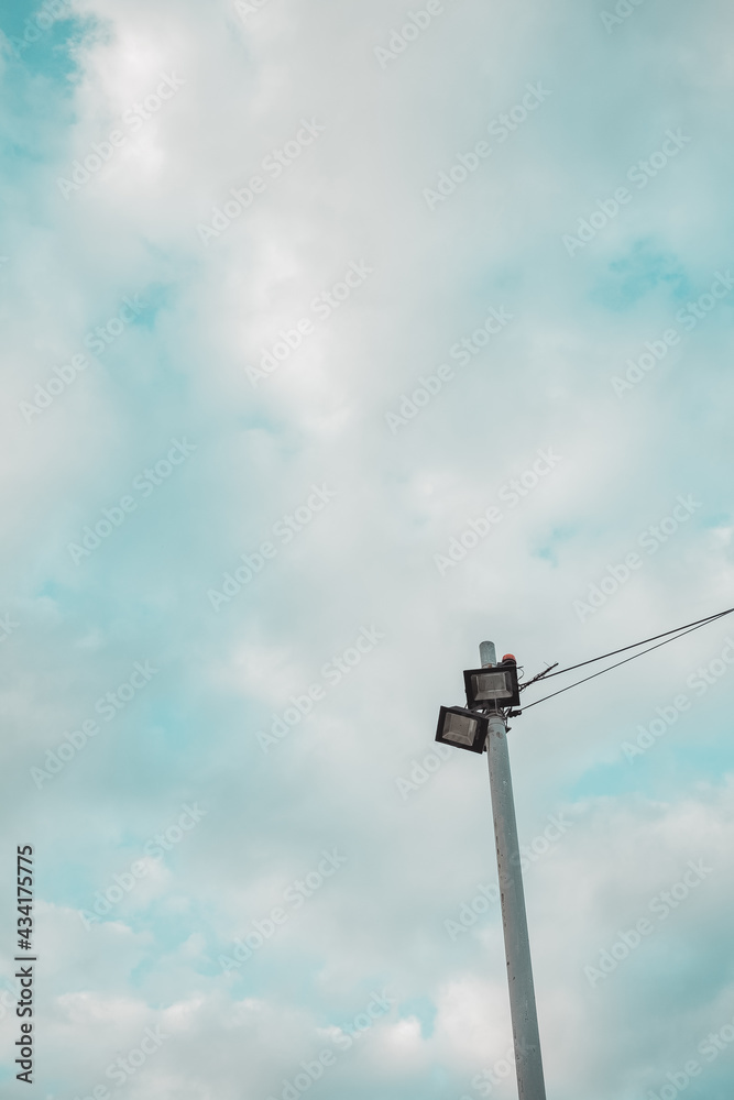 Lamp post under partly cloudy sky