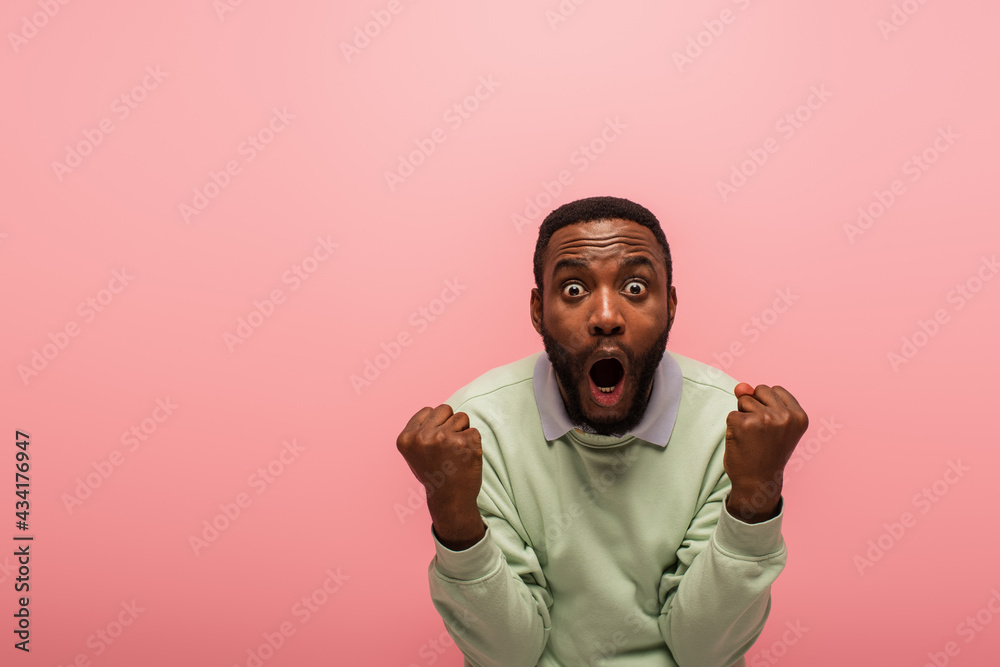 Obraz premium Excited african american man doing yes gesture isolated on pink