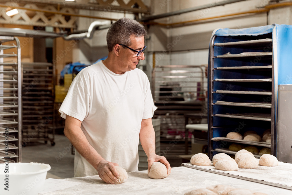 old authentic baker in bakery making organic bread and taking care of it with passion and care. concept of traditional manual bread preparation in bread factory old authentic baker in bakery making organic bread and taking care of it with passion and care. concept of traditional manual bread preparation in bread factory