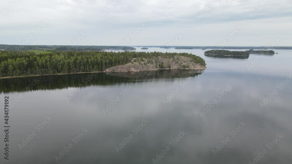 Flight under rocks and pine forest at a spring day. Sea shore. Finnish archipelago, Finland. Cinema 4k footage.