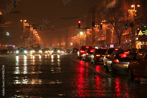 Main street at night. Night city lights. Car headlights on the night street. Slush, winter, city. Bung. Cars at traffic lights