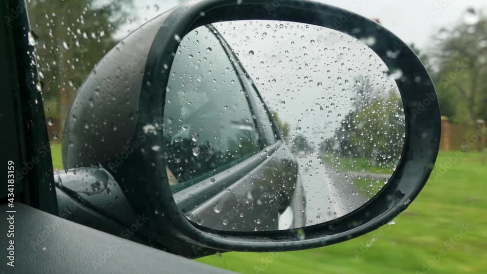 view of a rain-fallen car mirror, while driving through heavy rainfall view of a rain-fallen car mirror, while driving through heavy rainfall
