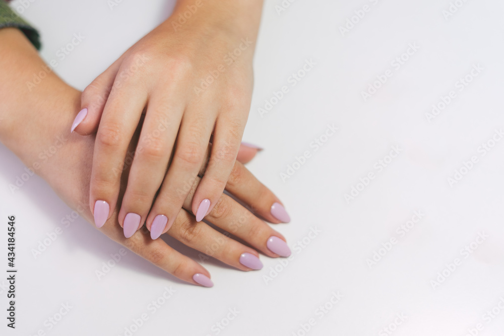 Manicure on a white background. Female hands with long nails. Girl's hands with a gentle pink manicure on a white background. Manicure on a white background. Female hands with long nails. Girl's hands with a gentle pink manicure on a white background.