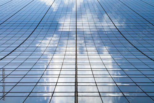 Tall modern skyscraper building with clouds reflected in the glass windows in Manhattan New York City NYC