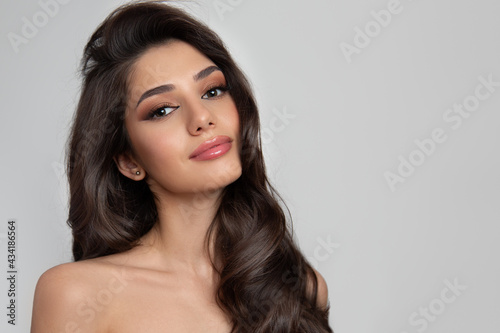 Print op canvas Portrait of a brunette with curly shiny hair and makeup