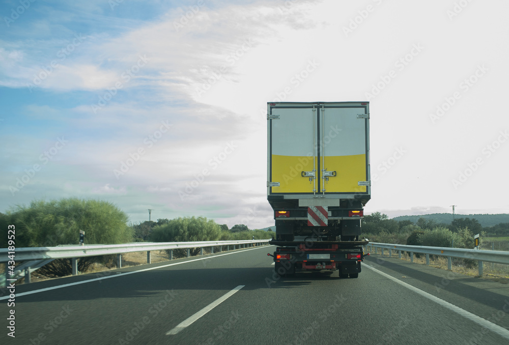 Heavy tow truck carrying semi-trailer truck on freeway