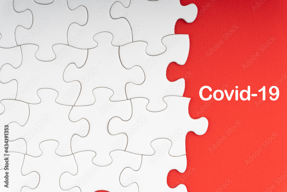 Fototapeta premium COVID-19 text with jigsaw puzzle on red background. Covid-19 and Coronavirus Concept