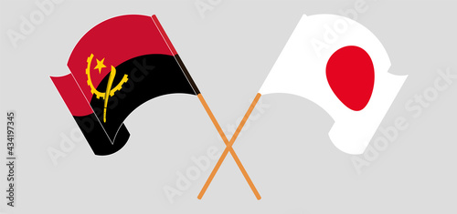 Crossed and waving flags of Angola and Japan
