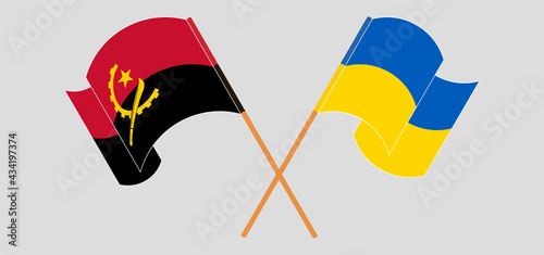 Crossed and waving flags of Angola and Ukraine