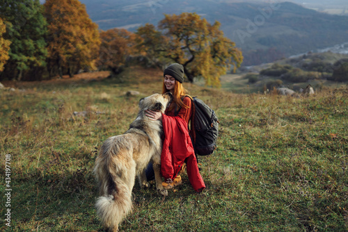 cheerful woman playing with dog outdoors mountains travel vacation