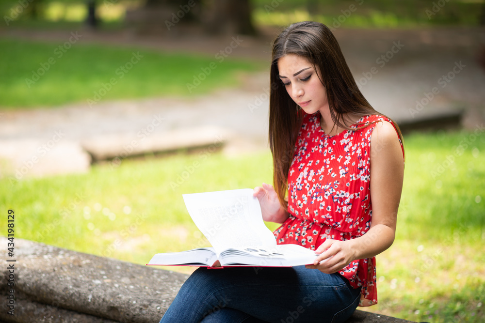 Obraz premium Student reading a book at the park