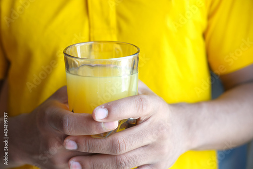 holding a glass of orange juice close up 