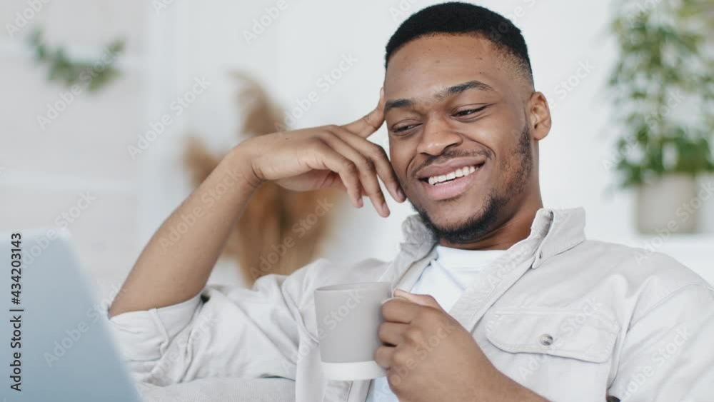 Portrait happy successful african man black ethnic guy male face looking at laptop screen video call conference chat online talking to webcam communicating in lockdown quarantine drinking tea coffee Portrait happy successful african man black ethnic guy male face looking at laptop screen video call conference chat online talking to webcam communicating in lockdown quarantine drinking tea coffee