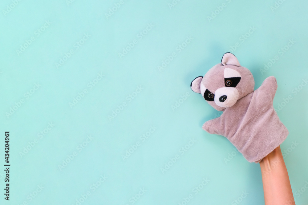 Puppet theater toys on a hand on a turquoise background. Childrens entertainment concept. Puppet theater toys on a hand on a turquoise background. Childrens entertainment concept.