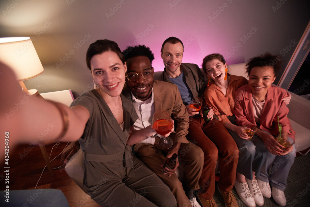 Obraz premium High angle view at friends taking selfie photo while enjoying party at home