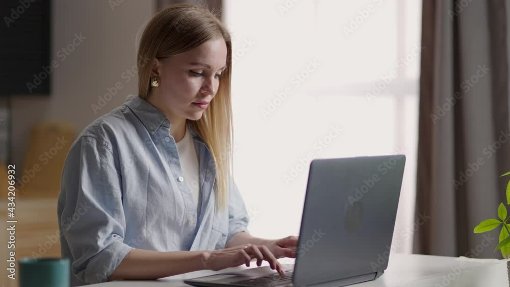 Mobile Office at home. Young woman sitting in kitchen at home working using on laptop computer. Lifestyle girl studying or working indoors. Freelance business quarantine concept Mobile Office at home. Young woman sitting in kitchen at home working using on laptop computer. Lifestyle girl studying or working indoors. Freelance business quarantine concept