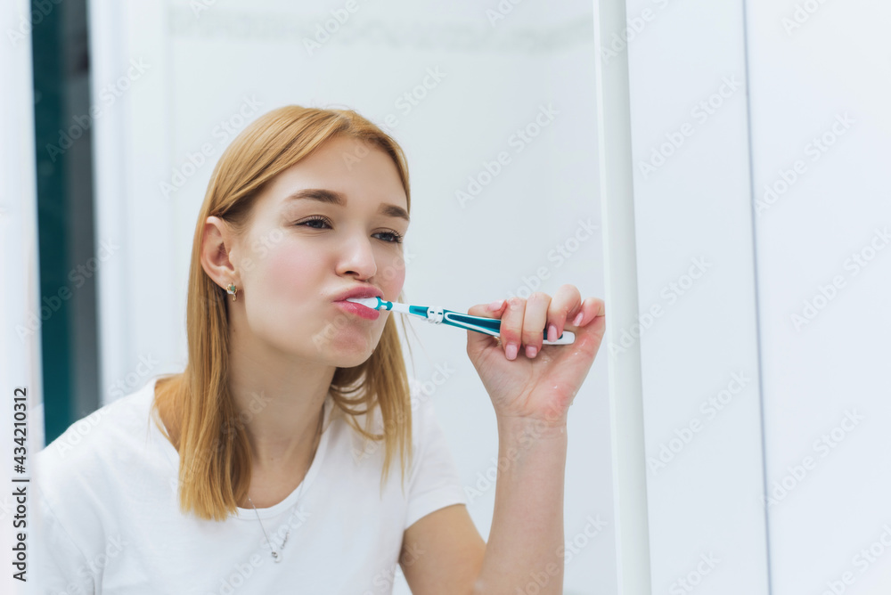 Young woman cleaning teeth with toothbrush in bathroom. Oral hygiene Young woman cleaning teeth with toothbrush in bathroom. Oral hygiene