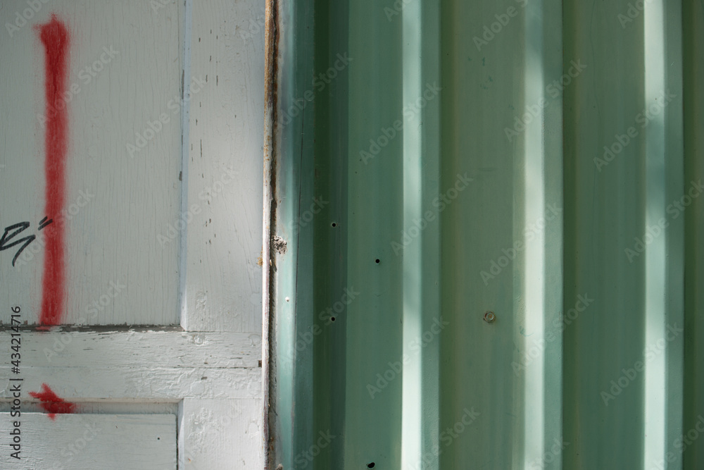 pale green corrugated metal siding and white garage door with sunlight effect