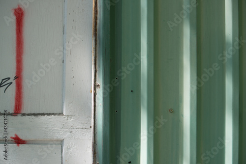 pale green corrugated metal siding and white garage door with sunlight effect