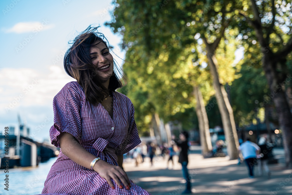 Fototapeta premium Portrait of a beautiful young woman outdoors in the city. Urban landscape. Travel and freelance lifestyle. Youth and beauty