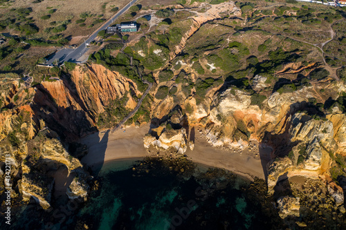 Camilo Beach at sunrise. Lagos, Algarve - Portugal. Portuguese southern golden coast cliffs. Sunny day aerial view.