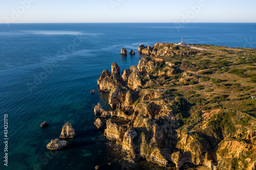 Camilo Beach at sunrise. Lagos, Algarve - Portugal. Portuguese southern golden coast cliffs. Sunny day aerial view.
