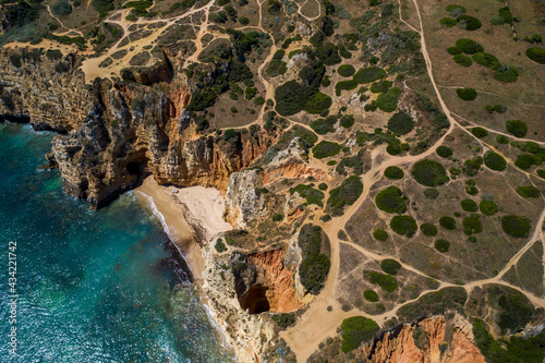 Camilo Beach in Lagos, Algarve - Portugal. Portuguese southern golden coast cliffs. Sunny day aerial view