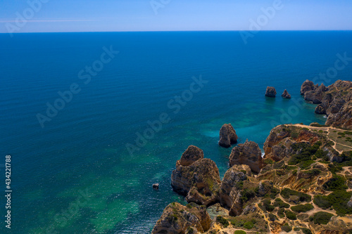 Camilo Beach in Lagos, Algarve - Portugal. Portuguese southern golden coast cliffs. Sunny day aerial view