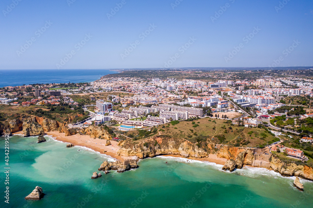 Dona Ana Beach in Lagos, Algarve - Portugal. Portuguese southern golden coast cliffs. Aerial view with city in the background. Camilo and pinhao beach.