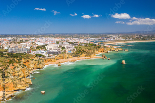 Fototapeta Naklejka Na Ścianę i Meble -  Dona Ana Beach in Lagos, Algarve - Portugal. Portuguese southern golden coast cliffs. Aerial view with city in the background