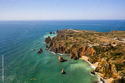 Ponta da Piedade lighthouse. Portuguese southern golden coast cliffs. Aerial view over city of Lagos in Algarve, Portugal.