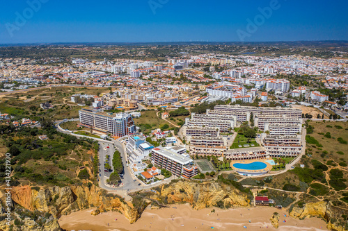 Dona Ana Beach in Lagos, Algarve - Portugal. Portuguese southern golden coast cliffs. Aerial view with city in the background