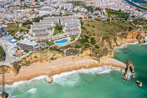 Dona Ana Beach in Lagos, Algarve - Portugal. Portuguese southern golden coast cliffs. Aerial view with city in the background