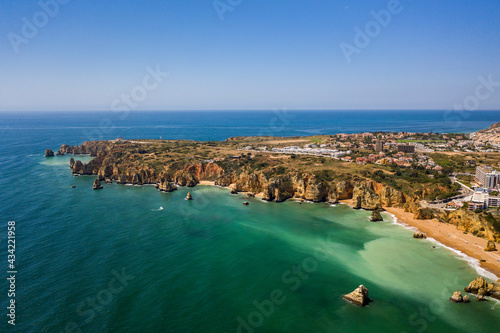 Ponta da Piedade lighthouse. Portuguese southern golden coast cliffs. Aerial view over city of Lagos in Algarve, Portugal.