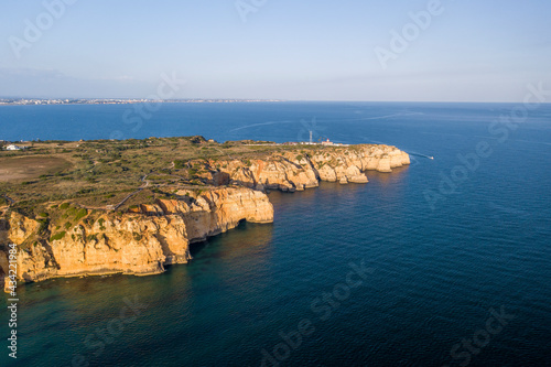 Ponta da Piedade lighthouse. Portuguese southern golden coast cliffs. Aerial view over city of Lagos in Algarve, Portugal.