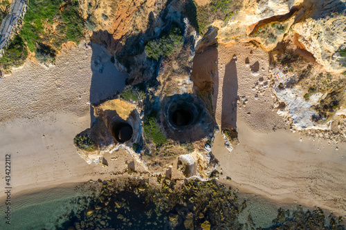 Camilo Beach in Lagos, Algarve - Portugal. Portuguese southern golden coast cliffs. Aerial view over hole in cliff.