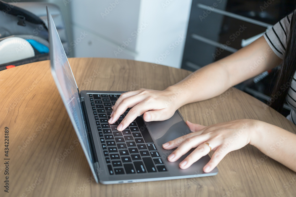 Working from home on laptop while typing chat to customer communicates on internet in home office Working from home on laptop while typing chat to customer communicates on internet in home office
