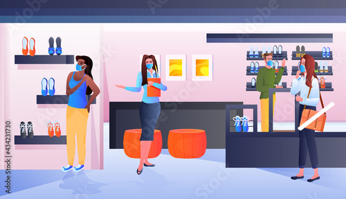 saleswoman in mask showing clothes to customers in fashion boutique coronavirus pandemic quarantine concept