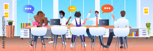 mix race businesspeople team in masks discussing during meeting chat bubble communication brainstorming