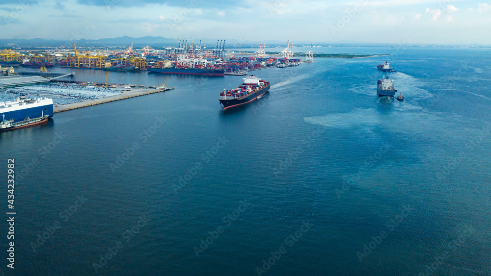 Aerial view from drone, Cargo vessel sail to the sea at port cargo ship. Professional business logistics and transportation of cargo ship.